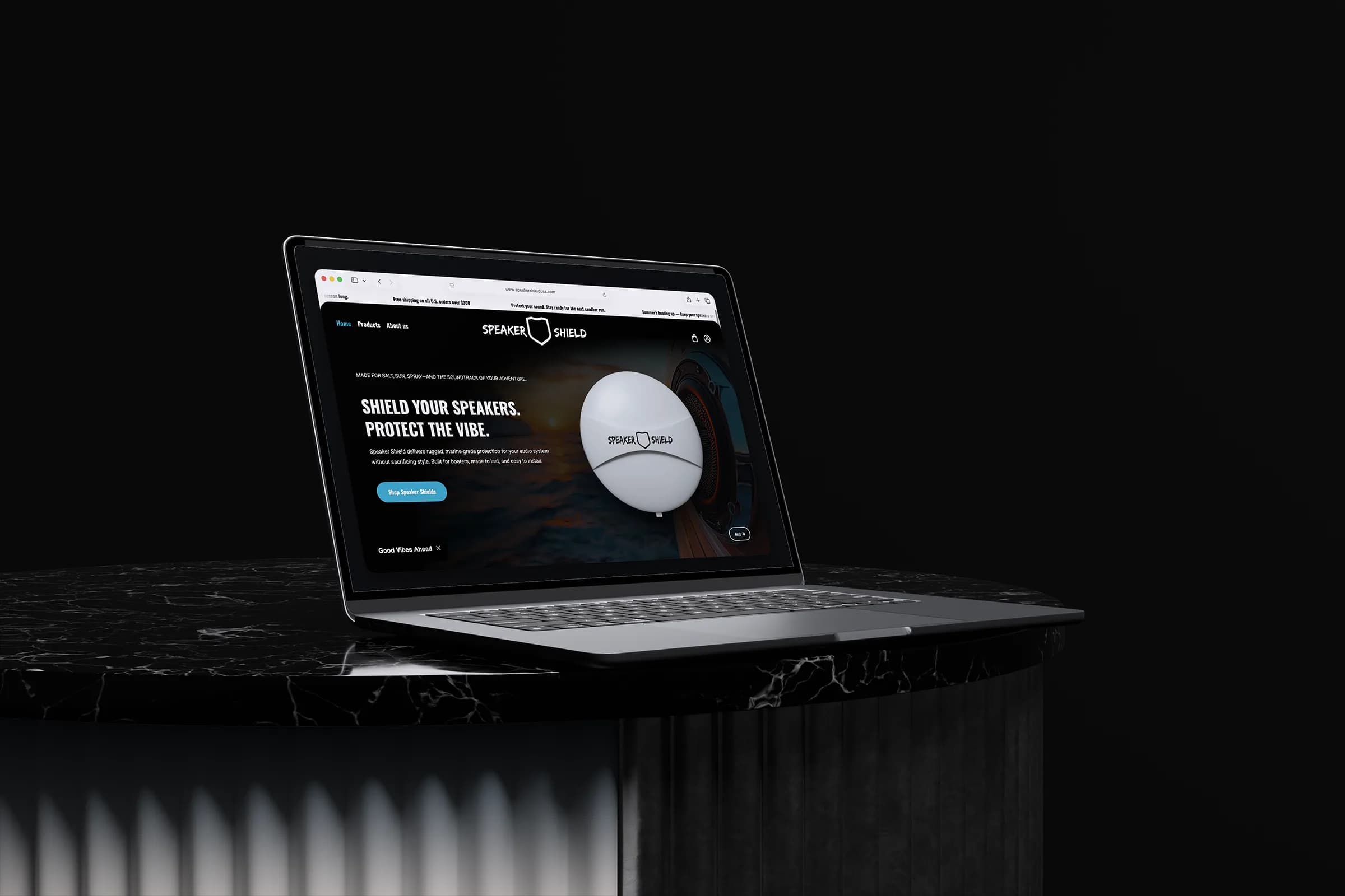 Speaker Shield storefront displayed on a laptop above a black marble pedestal.